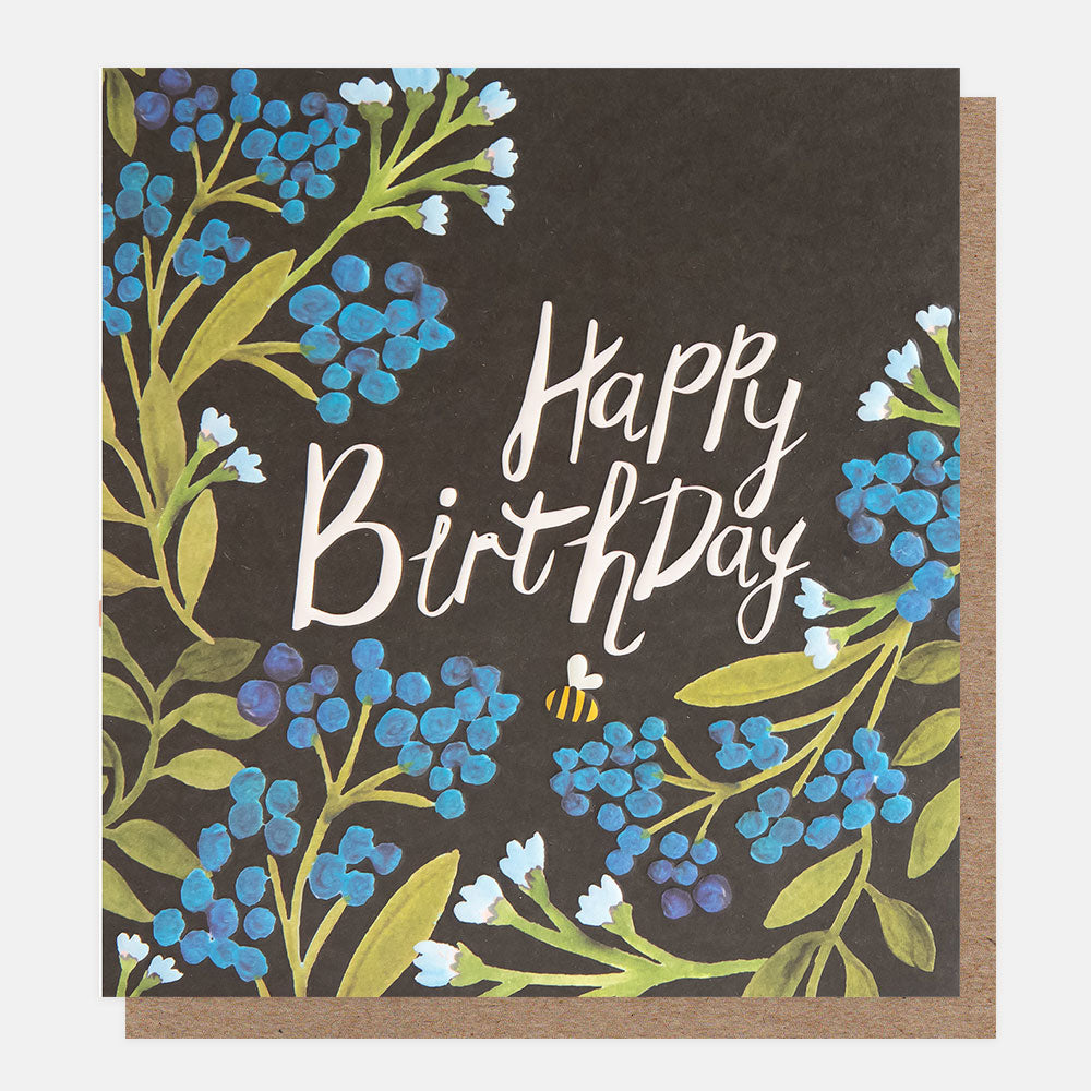 birthday card featuring a bee amidst blue flowers and 'happy birthday' message in white handwritten style lettering over a navy background
