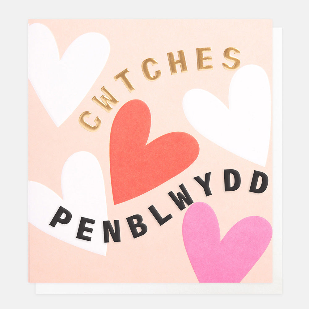 welsh language birthday card featuring white, red and pink hearts on a light peach background and the text cwtches penblwydd
