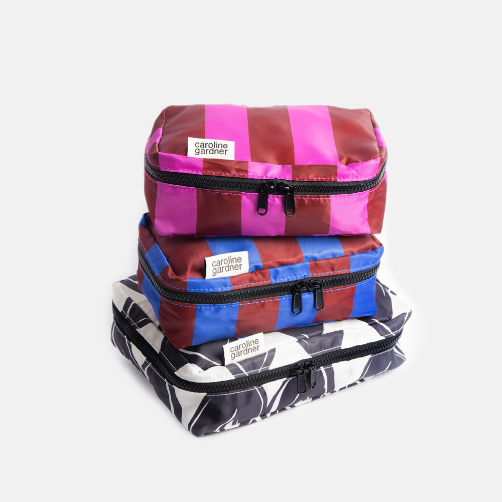 set of 3 packing cubes with 2 small in colourful stripe designs and one large in black & white hearts design