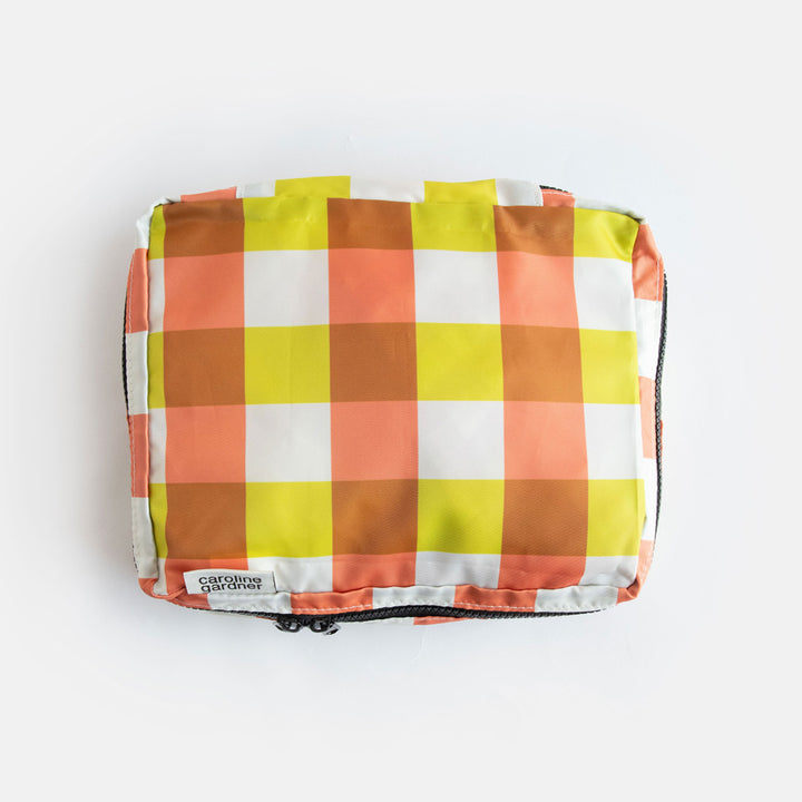small packing cube in a yellow, orange and brown check design
