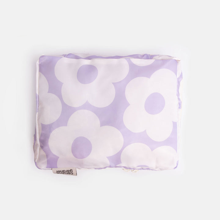 Purple packing cube with white floral pattern on a white background