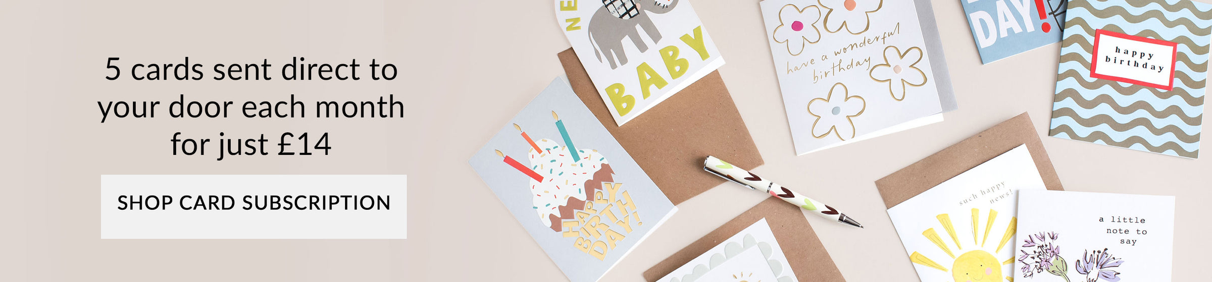 A promotional banner showing several greeting cards and envelopes arranged on a beige background, with text reading '5 cards sent direct to your door each month for just £14' and a 'SHOP CARD SUBSCRIPTION' button.