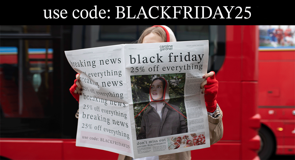 woman holding a newspaper while a red london bus drives past in the background