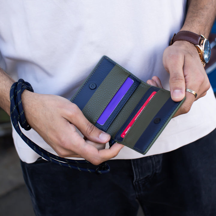 Person holding a striped wallet with purple and red accents