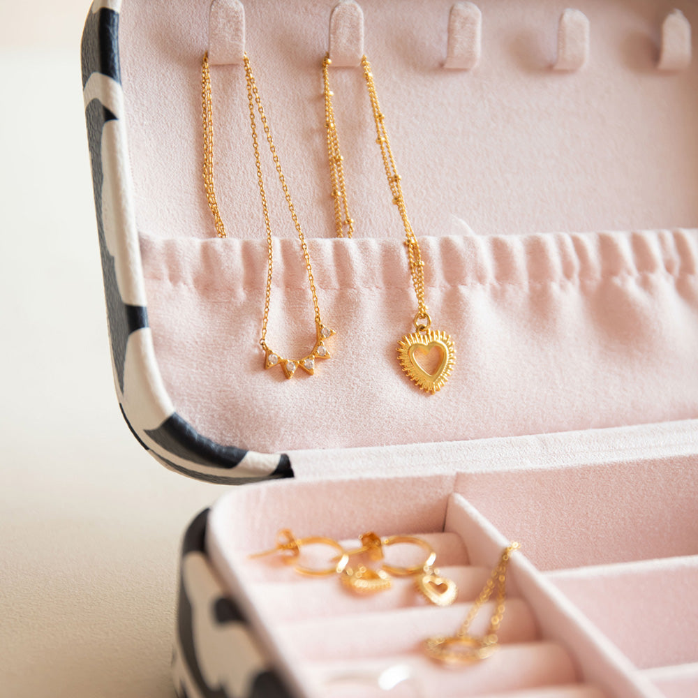 Gold necklaces and earrings in a jewellery box with pink interior