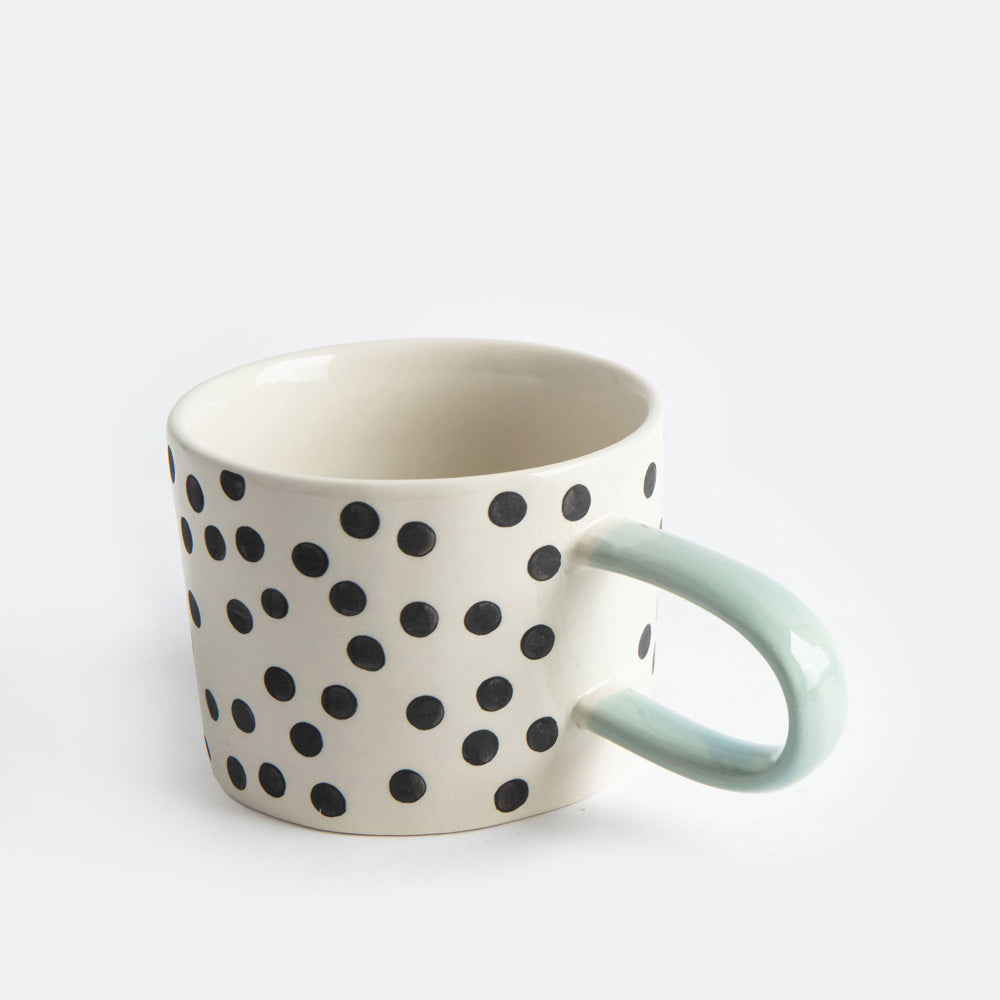 hand painted ceramic stoneware mug with small black dots design and a light blue elongated handle