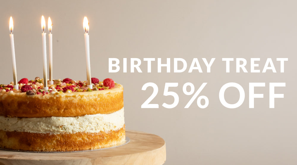 A half-layer cake with red berries and lit candles sits on a wooden stand against a beige background, with large white text reading 'BIRTHDAY TREAT 25% OFF'.