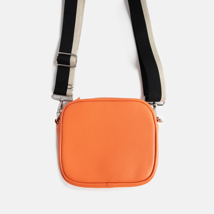 vegan leather orange camera bag with silver zip and hardware, monochrome webbing adjustable straps and spot print lining