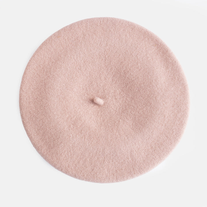 A dusty pink felt beret hat photographed from directly above on a clean white background.