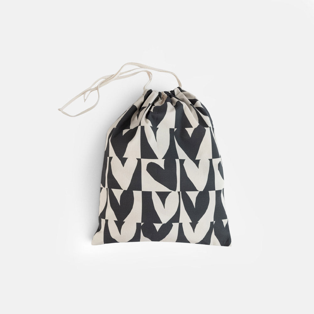 A fabric drawstring pouch featuring a repeating black and cream geometric heart pattern, shown against a plain light gray background.