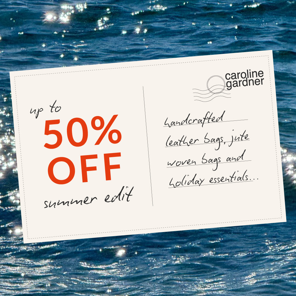 A promotional postcard-style graphic with the text 'up to 50% OFF summer edit' and the Caroline Gardner logo, placed over a blue ocean background. Handwritten text on the card mentions leather bags, jute woven bags, and holiday essentials.