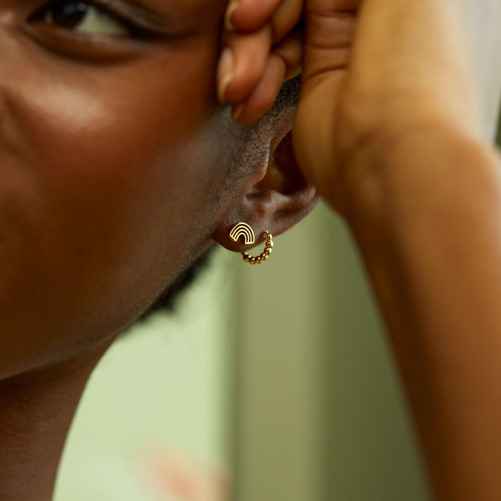 gold plated rainbow stud earrings worn with gold beaded hoop earrings