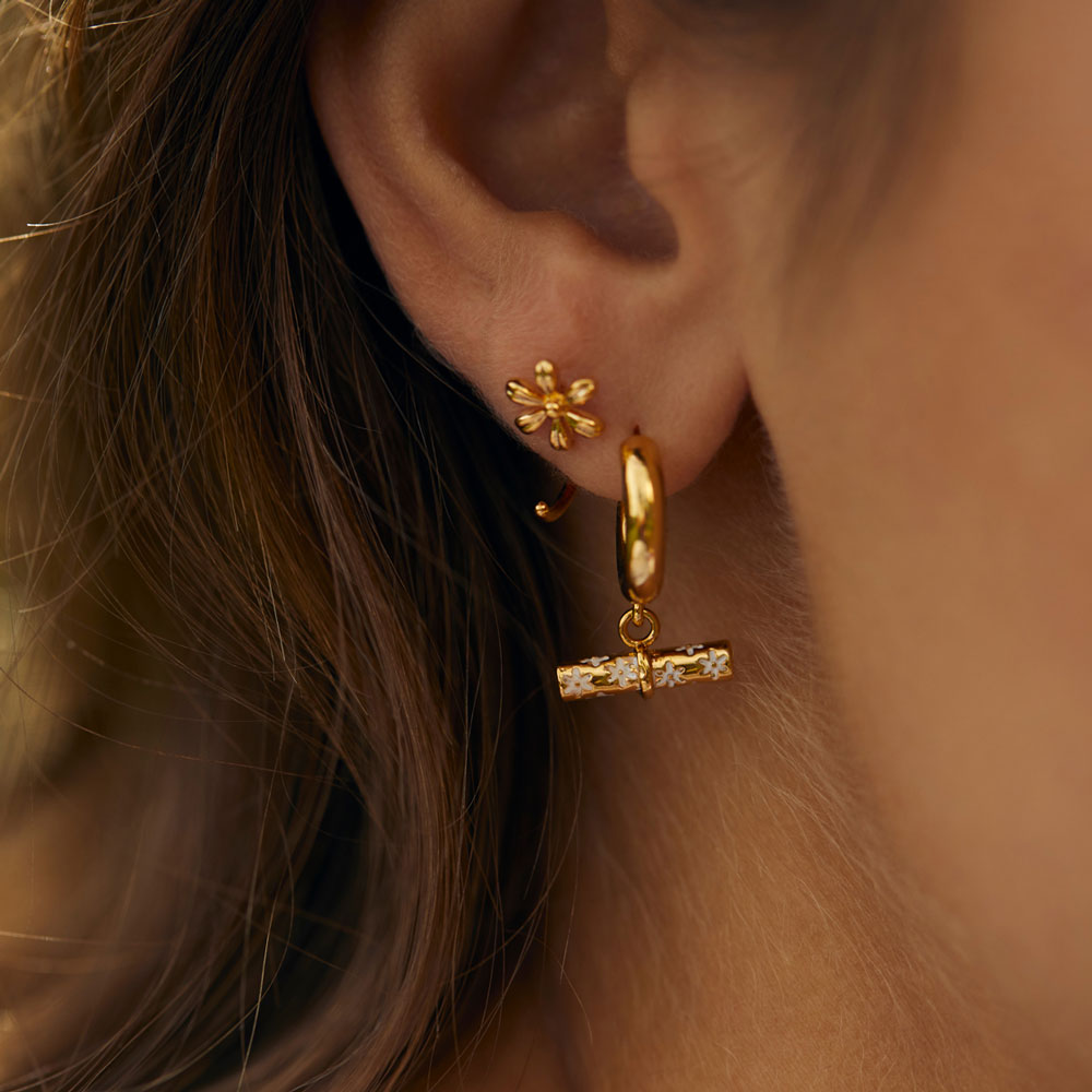 gold plated t bar earrings worn with a flower stud